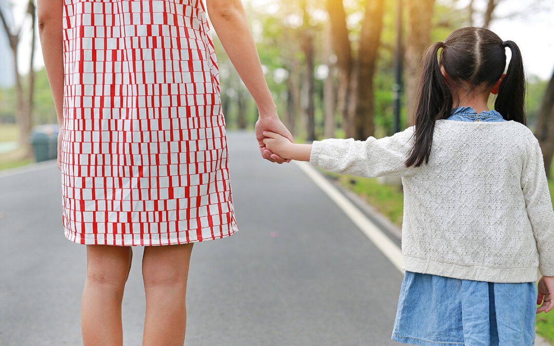 Close-up mom and daughter holding hands in the outdoor nature ga